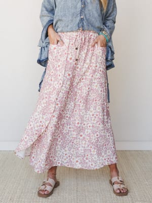 A flowy floral midi skirt in dusty rose paired with a chambray ruffle top and buckle sandals — the kind of outfit that feels just as good at a farmers market as it does at brunch.