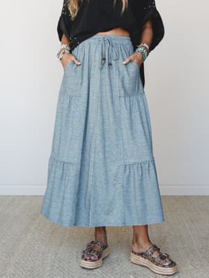 A heather teal tiered maxi skirt styled with a black crop top and leopard print platform sandals — the kind of effortless, pockets-included outfit that makes a Tuesday feel intentional.