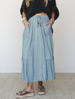 A heather teal tiered maxi skirt styled with a cropped black top and leopard print platform sandals — the kind of effortless, put-together look that works just as hard at the farmers market as it does at a rooftop dinner.