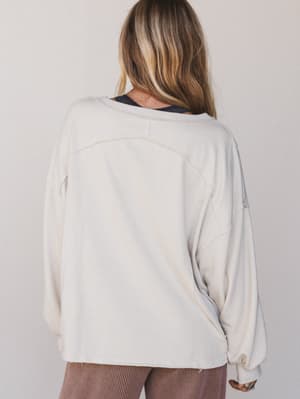 Person wearing a light gray sweater with a neutral background