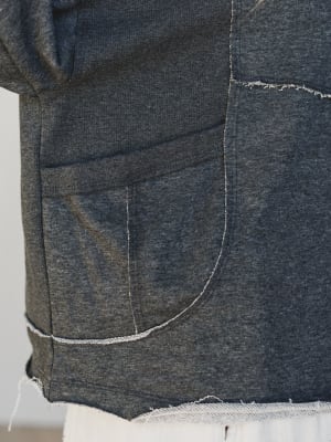 Close-up of a dark blue denim fabric with visible stitching on a plain background