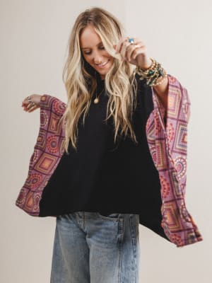 Woman wearing a black boho top with red patterned fabric on the sleeves