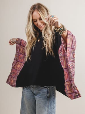 Woman wearing a black boho top with red patterned fabric on the sleeves