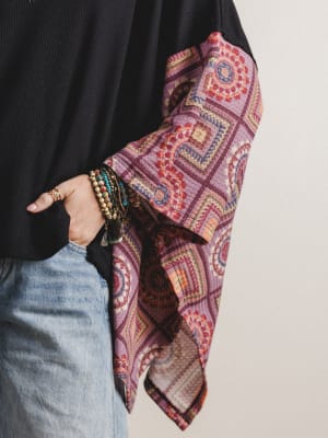 Close-up of sleeve detail on black boho top with red patterned sleeves