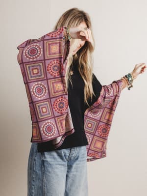 Woman wearing a black boho top with red patterned fabric on the sleeves