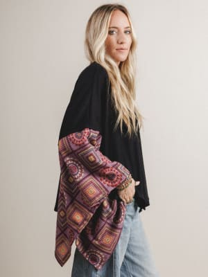 Woman wearing a black boho top with red patterned fabric on the sleeves