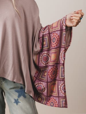 Person wearing a patterned sleeve with a neutral background