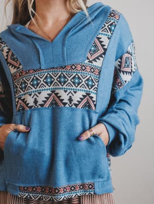 Blue hoodie with patterned design on a plain background