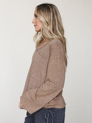 A relaxed long sleeve top in warm heathered brown styled with navy drawstring pants — the kind of effortless, cozy outfit that looks like you tried just enough.