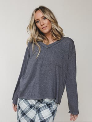 A relaxed charcoal v-neck long sleeve top styled with plaid pants — the kind of outfit that makes staying in feel completely intentional.