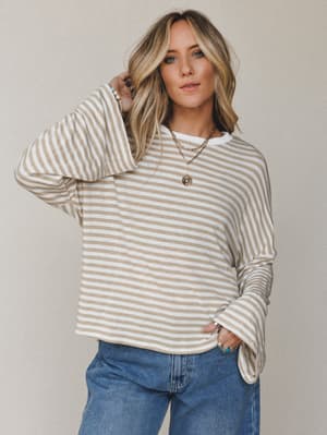 A relaxed striped bell sleeve top in warm tan and white pairs effortlessly with wide-leg denim — the kind of easy, put-together look that feels like you tried just enough.