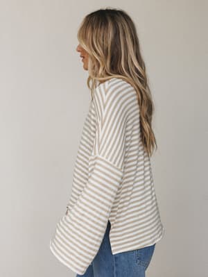 A relaxed, oversized striped top with wide bell sleeves shot in soft profile — the kind of top that looks like it was made for slow mornings and easy days.