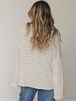 A back-facing shot of a relaxed striped bell sleeve top paired with blue denim — the kind of effortless, lived-in combo that makes getting dressed feel easy.