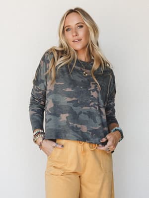 A relaxed cropped long sleeve in a faded camo print paired with warm golden wide-leg pants — the kind of effortless, thrown-together outfit that somehow always looks intentional.