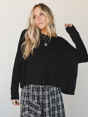 A relaxed oversized black long sleeve top paired with plaid wide-leg pants — the kind of effortless combo that feels intentional without trying too hard.