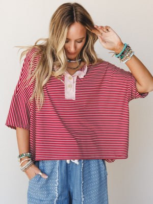 A relaxed oversized striped top in marsala and white styled with textured denim shorts and stacked boho bracelets — the kind of effortless outfit that looks like you just threw it on and somehow nailed it.