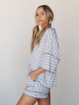A relaxed striped matching set — oversized top and mini shorts — shot in profile against a clean studio wall, with the kind of effortless ease that makes you want to wear it everywhere from the farmers market to a lazy beach day.