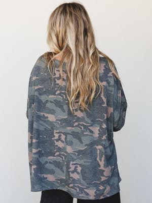 A relaxed, oversized camo long sleeve top shot from the back, with a soft dusty color palette and easy drape that feels more 'weekend errand run' than anything militaristic.