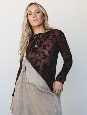 A floral burnout velvet long sleeve top in deep brown layered over a corduroy skirt — the kind of outfit that feels intentional without trying too hard, styled with gold layered necklaces and a turquoise ring.