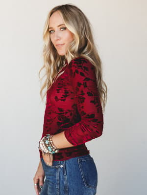 A velvet floral burnout top in deep wine pairs with denim for that effortless 'going somewhere fun tonight' energy — stacked boho bracelets doing all the right things.