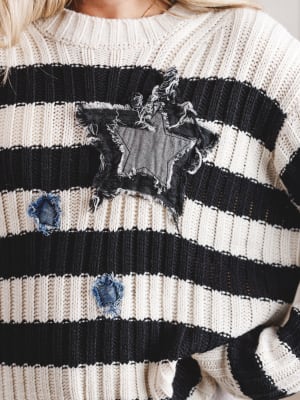 Close-up of a black and white striped sweater with star designs.