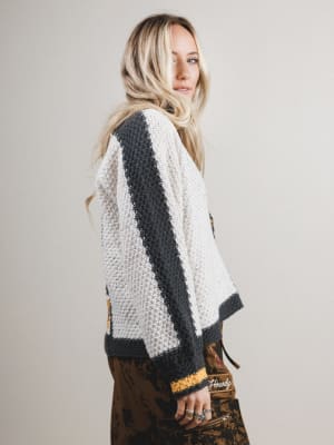 Woman wearing a black and white patterned sweater against a plain background