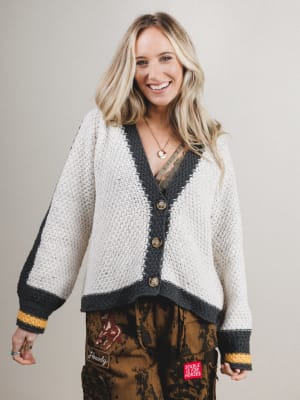 Woman wearing a patterned cardigan with a neutral background