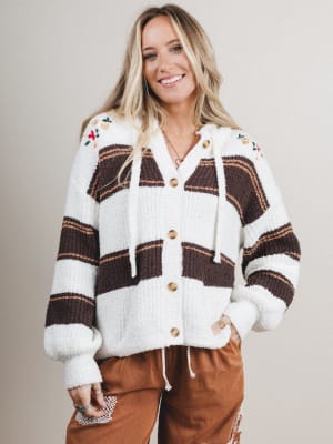 Woman wearing a patterned cardigan with a neutral background