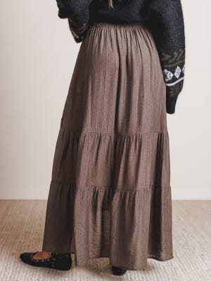 Brown tiered skirt worn by a person on a neutral background