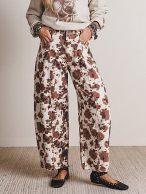 Person wearing a patterned outfit with wide-leg pants and a graphic sweatshirt.
