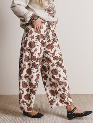 Person wearing floral pants with a neutral background