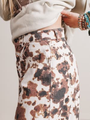 Person wearing a patterned skirt with a neutral background