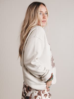 Woman wearing a white sweatshirt on a plain background
