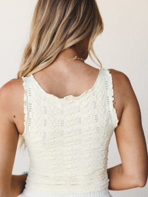 A close-up back shot of a cream textured knit cami with delicate pointelle detailing and scallop edges — soft, effortless, and just the kind of top you reach for without thinking.