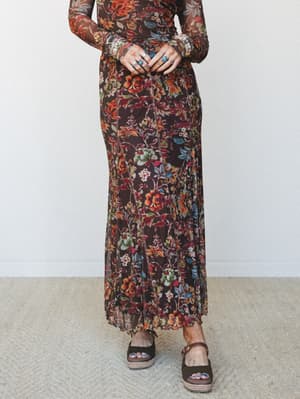 A rich chocolate floral mesh maxi skirt styled with a matching long-sleeve floral top and olive platform sandals — the kind of head-to-toe autumn print moment that feels intentional, not costumey.