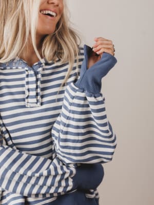 Person wearing a blue and white striped shirt with a plain background