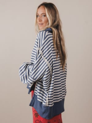 Woman wearing a blue and white striped shirt with a beige background