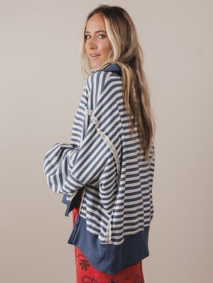 Woman wearing a blue and white striped shirt with a beige background