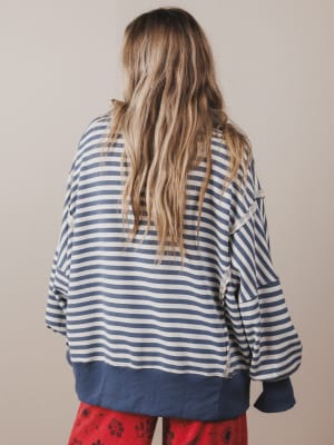 Person wearing a blue and white striped shirt with red pants on a plain background