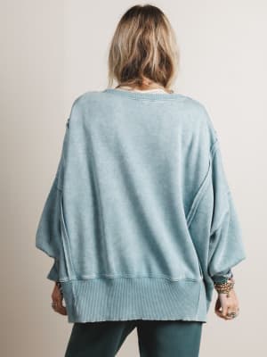Person wearing a light blue sweater against a neutral background
