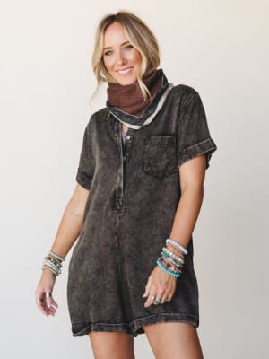 A mineral-washed black romper styled with a printed bandana scarf and stacked turquoise beaded bracelets — the kind of effortless outfit that looks like you tried just enough.