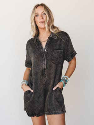 A mineral-washed black romper worn with stacked turquoise bracelets and a delicate choker — relaxed and a little undone in the best way, like something you'd throw on and somehow look completely put-together.