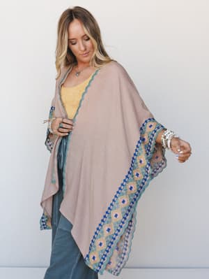 A flowy mauve kimono with bold geometric and floral border trim layers effortlessly over a golden yellow lace tank and relaxed jeans — the kind of outfit that looks like you tried just enough.
