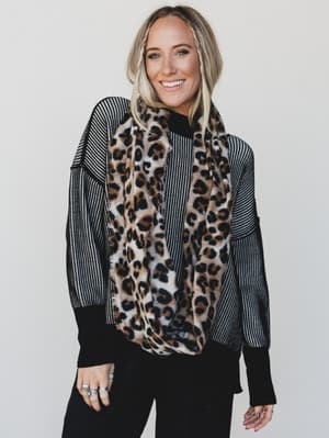 Person wearing a leopard print scarf with a neutral background