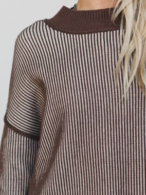 Close-up of a brown and white striped sweater with a plain background