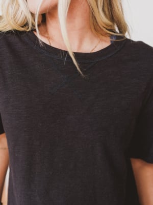 Person wearing a black t-shirt with a blurred background