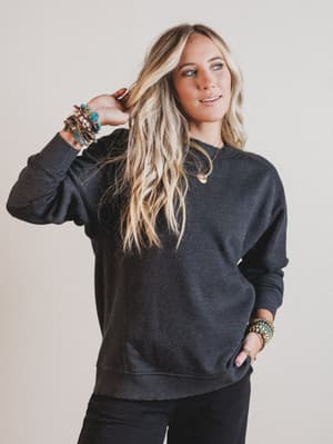 Woman wearing a dark gray sweatshirt against a plain background