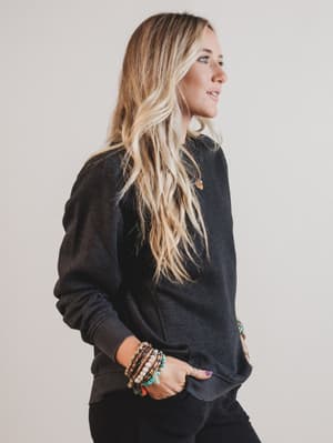 Woman wearing a black sweater with a neutral background