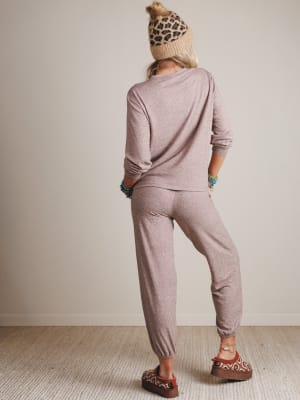 Person wearing a mauve outfit with a leopard print beanie in a neutral setting