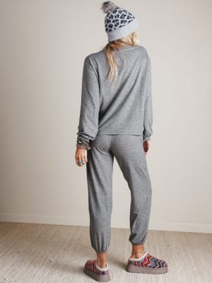 Person wearing a gray outfit with a leopard print beanie indoors.